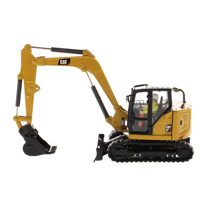 Model of a Caterpillar 308 CR Mini Hydraulic Excavator with Operator on a White Background
