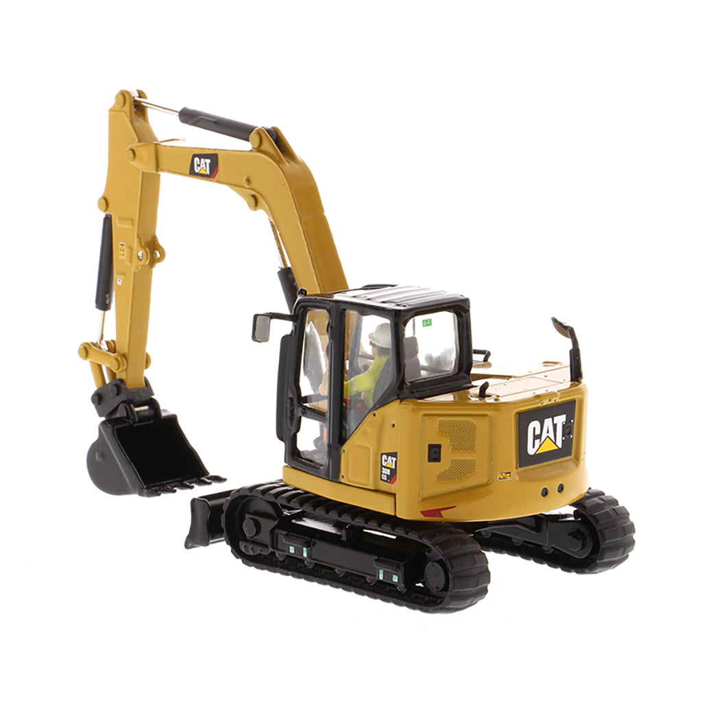 Model of a Caterpillar 308 CR Mini Hydraulic Excavator with Operator on a White Background