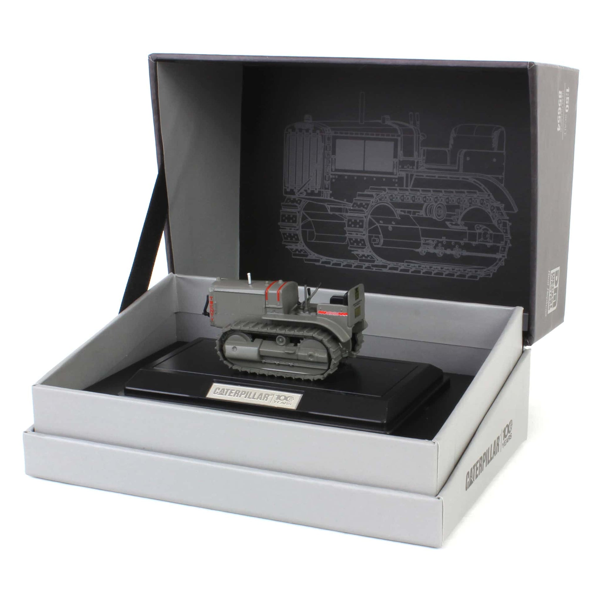 Model of a Caterpillar crawler tractor on a display box with a black and white illustration on the lid.