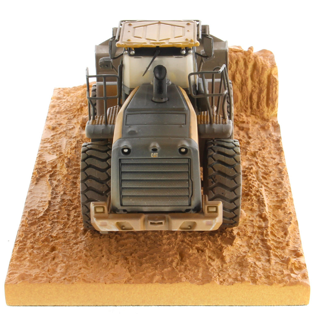 1:50th Scale Diecast Model of a Caterpillar 966M Wheel Loader with a Weathered Paint Scheme on a Tan Construction Site Base Plate on a White Background
