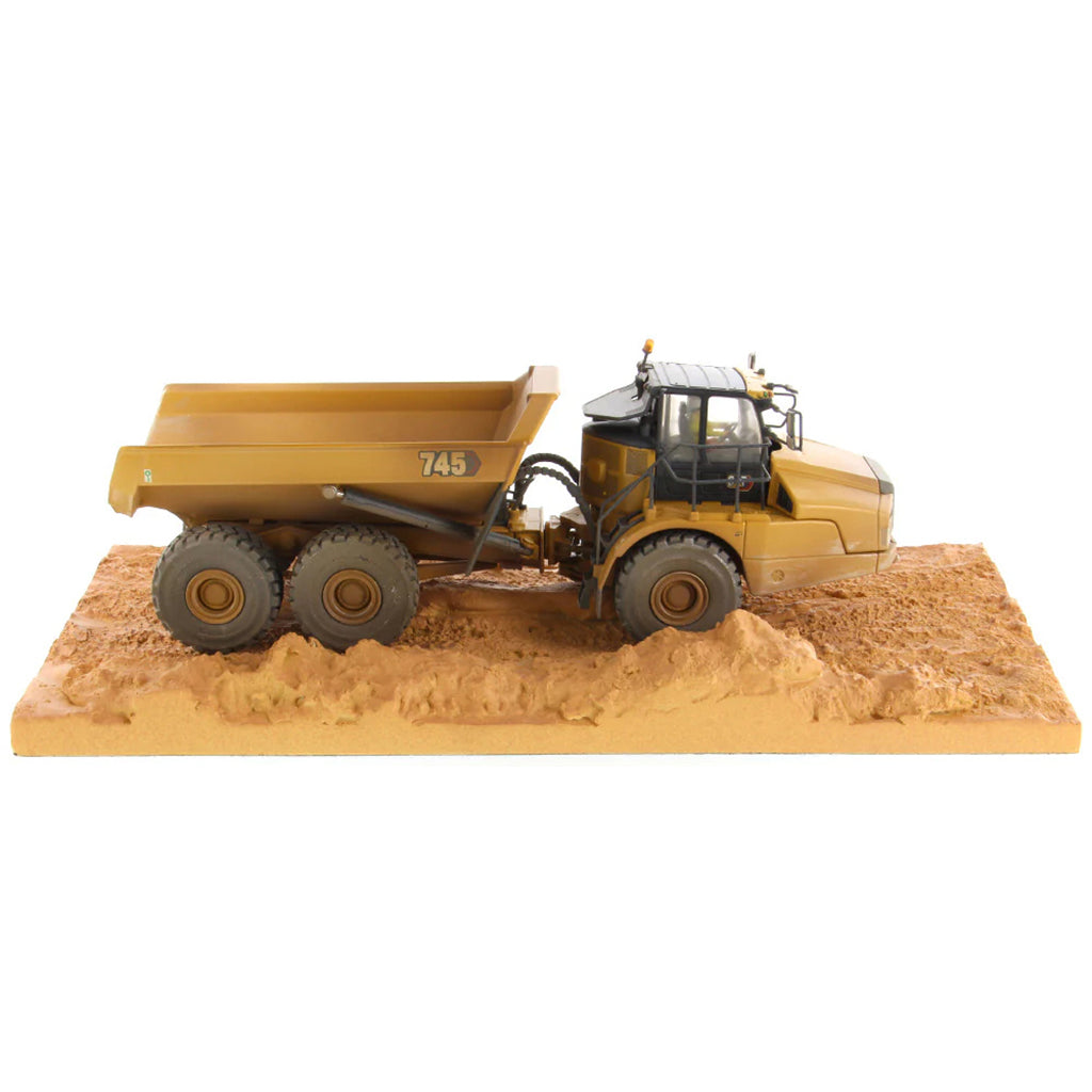 Model of Weathered Caterpillar 745 Articulated Dump Truck Mounted on a Simulated Dirt Road Base on a White Background