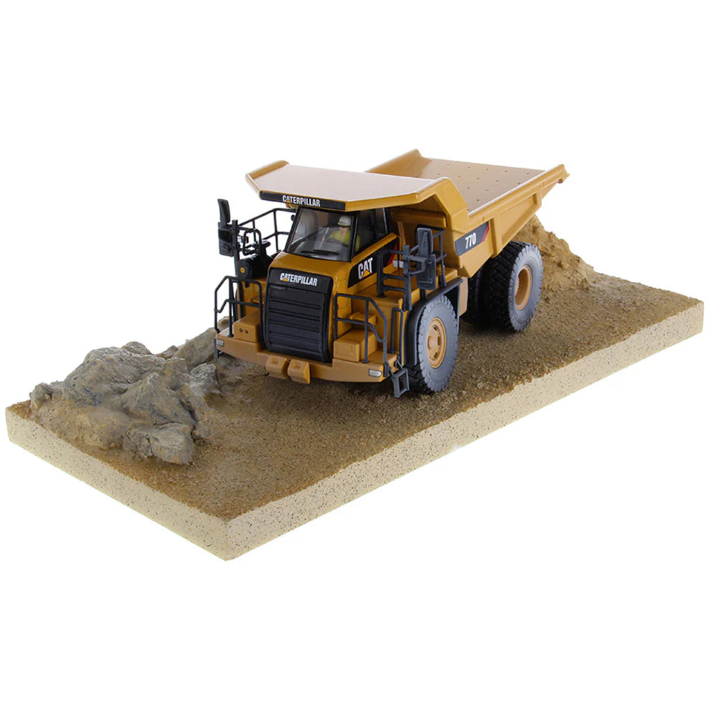 Model of a Weathered Caterpillar 770 Off-Highway Dump Truck Mounted on a Simulated Dirt & Rock Base on a White Background
