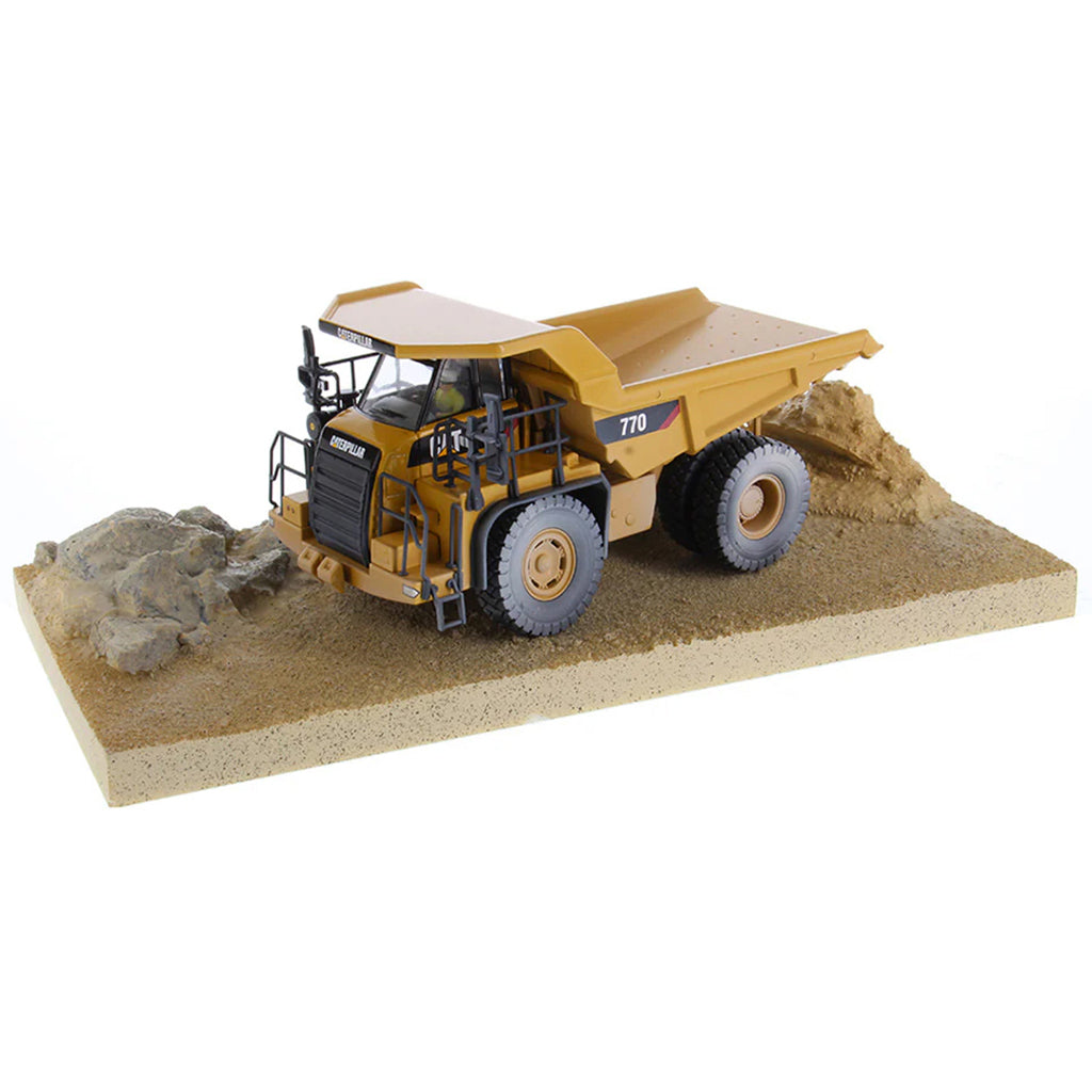 Model of a Weathered Caterpillar 770 Off-Highway Dump Truck Mounted on a Simulated Dirt & Rock Base on a White Background