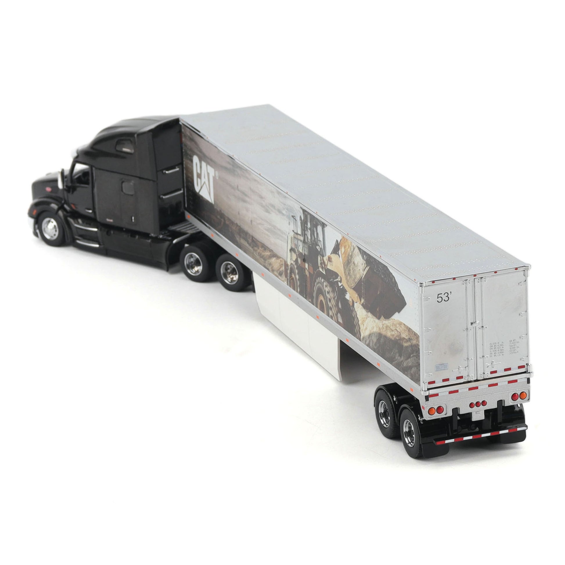 A diecast model of a semi-truck with a black cab and a white trailer printed with a CAT construction graphic, shown on a white background.