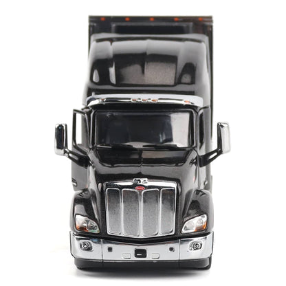 A black die-cast metal model semi-truck cab with chrome grille and mirrors, photographed from the front against a plain white background.