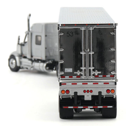 A detailed model of a semi-truck with a black cargo box shown from the rear three-quarter view, with the front cab blurred in the background on a white studio backdrop.