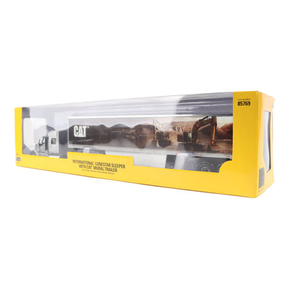 A toy model of an International Lonestar sleeper trailer with a CAT animal trailer, shown inside its yellow retail packaging on a white background.