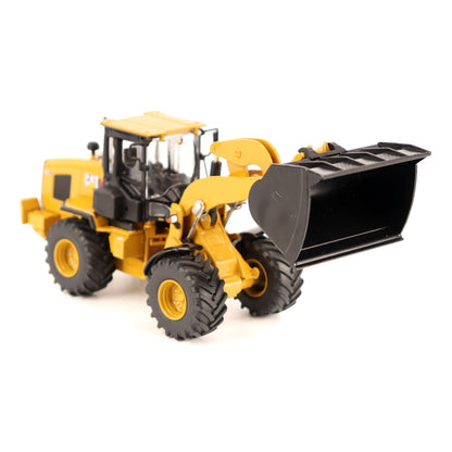 A yellow and black CAT wheel loader toy or model with a large black front bucket, photographed on a clean white background.