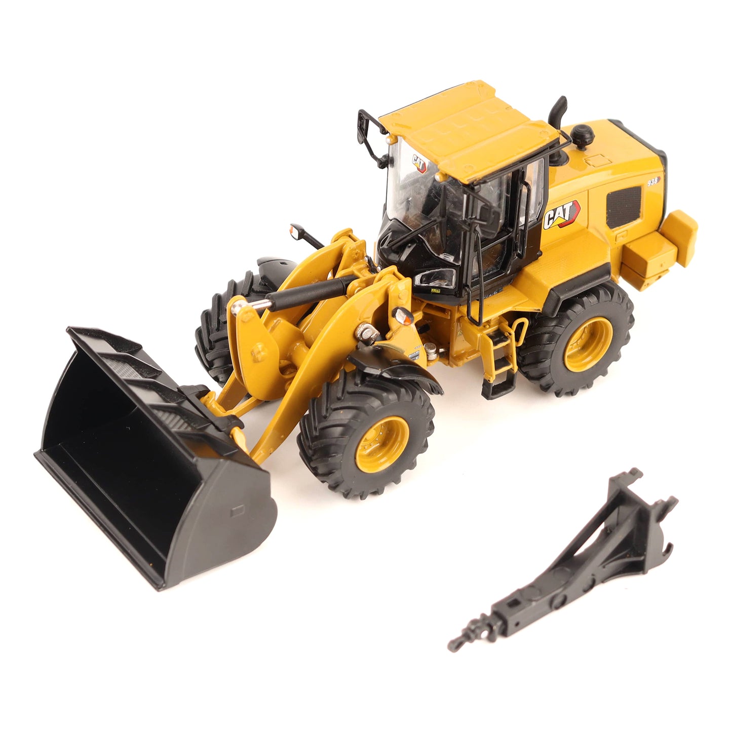 Yellow CAT toy construction vehicle with a black front bucket and a separate black attachment piece shown on a white background.