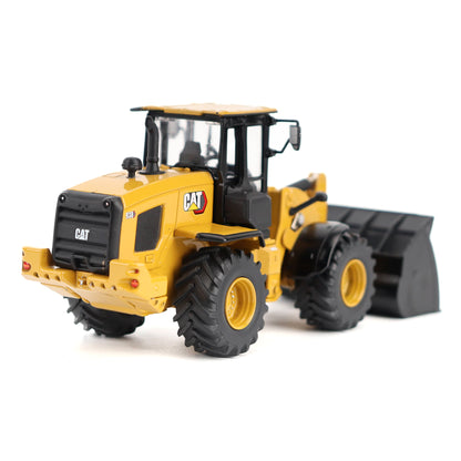 A yellow and black CAT wheel loader toy or model with a front bucket attachment, photographed on a clean white studio background.