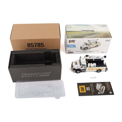 A 1:50 scale CAT Service Truck building set from Transport Series, showing the brown product box, black foam insert, clear plastic tray, instruction booklet, and the assembled white and yellow truck model next to its retail box.
