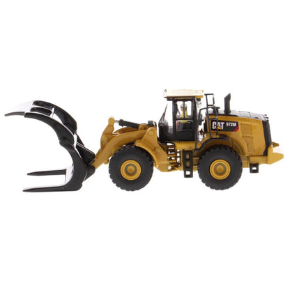 1:50th Scale Diecast Model of a Yellow and Black Caterpillar 972M Wheel Loader with Log Forks on a White Background