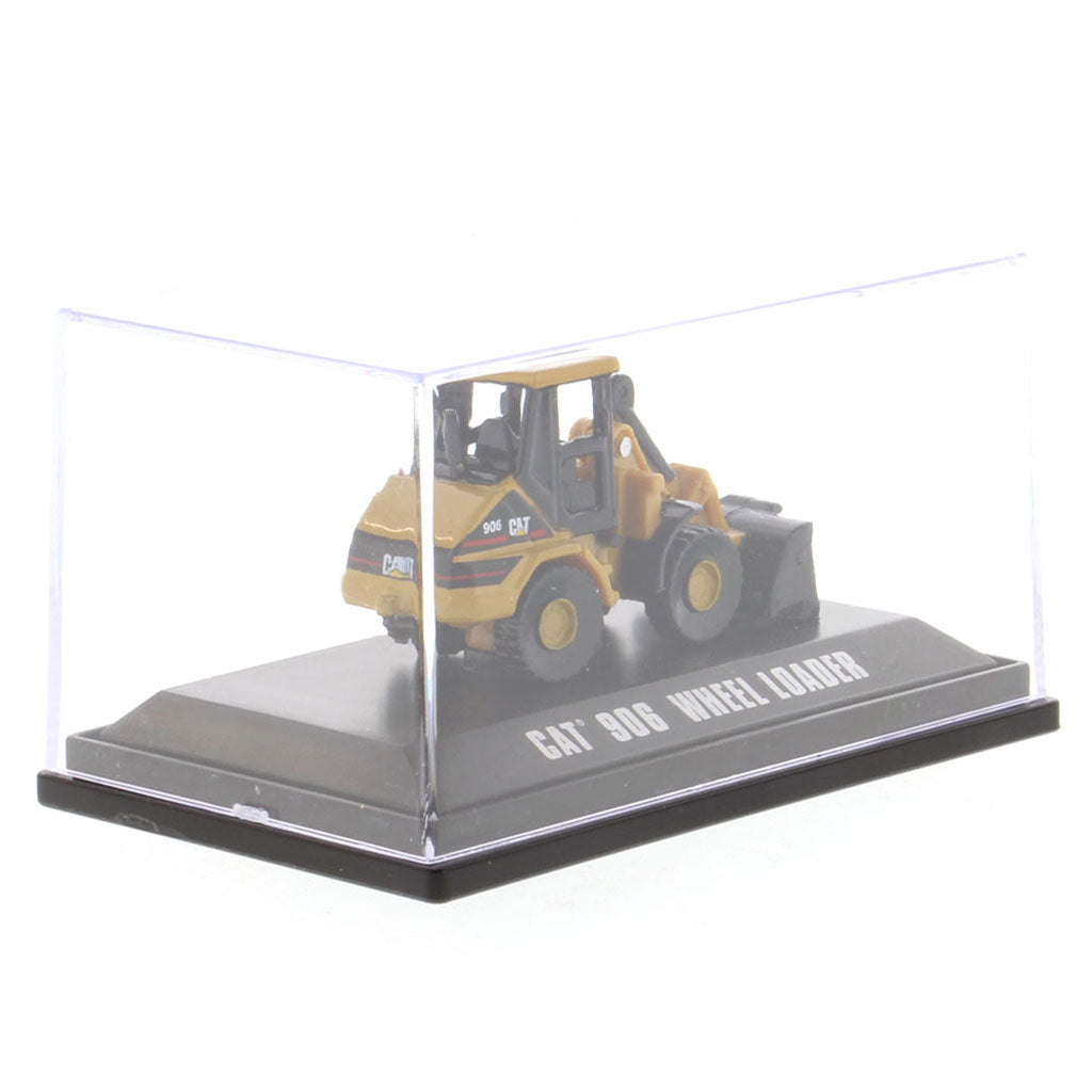 A yellow and black CAT 906 wheel loader toy model displayed inside a clear plastic display case on a black base with white text reading 'CAT 906 WHEEL LOADER'.