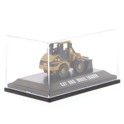 A yellow and black CAT 906 wheel loader toy model displayed inside a clear plastic display case on a black base with white text reading 'CAT 906 WHEEL LOADER'.