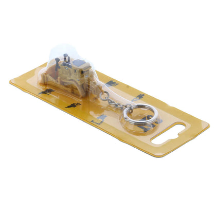 Model bulldozer keychain on a yellow card with a white background