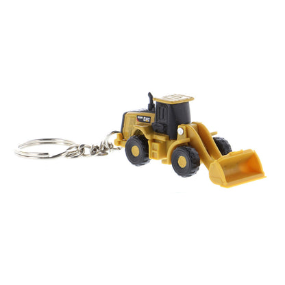 A miniature yellow and black toy wheel loader keychain with a metal key ring attached, shown on a plain white background.