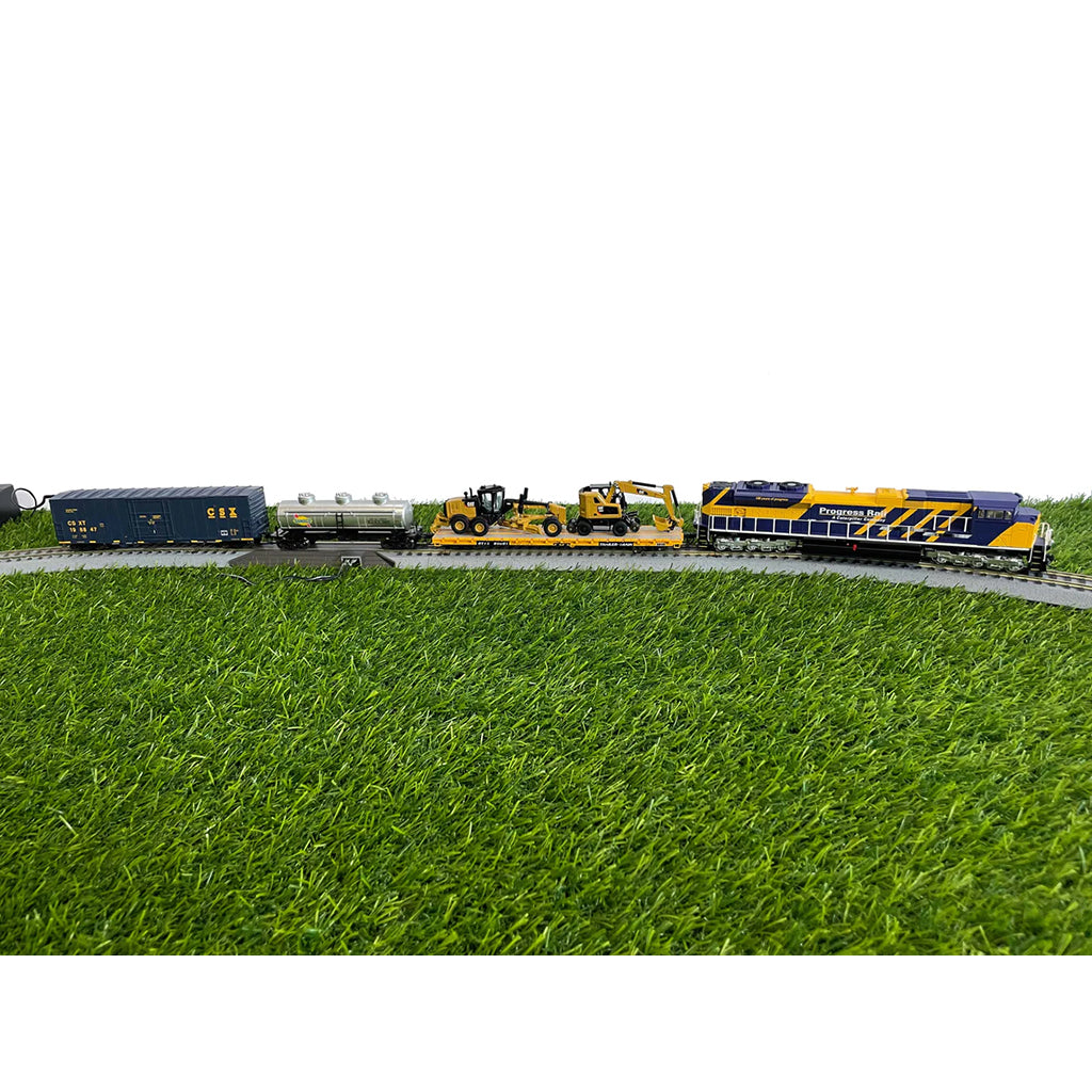Model train set on a grassy field with a white background
