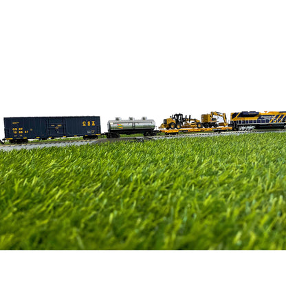 Model trains on a track with grass in the foreground
