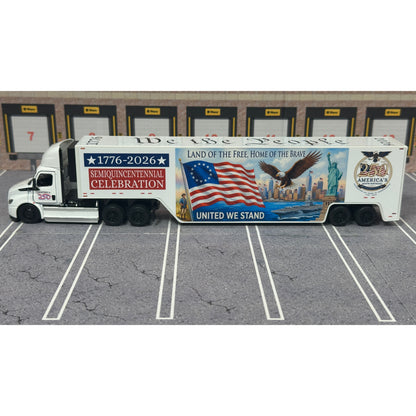 A diecast model of a Freightliner Cascadia semi-truck parked in a simulated parking lot. The trailer features a detailed historical design celebrating the United States' 250th anniversary with 'We the People' written on the top, alongside an American flag, eagle, and city skyline graphic with the text 'Land of the Free Home of the Brave' and 'United We Stand'.