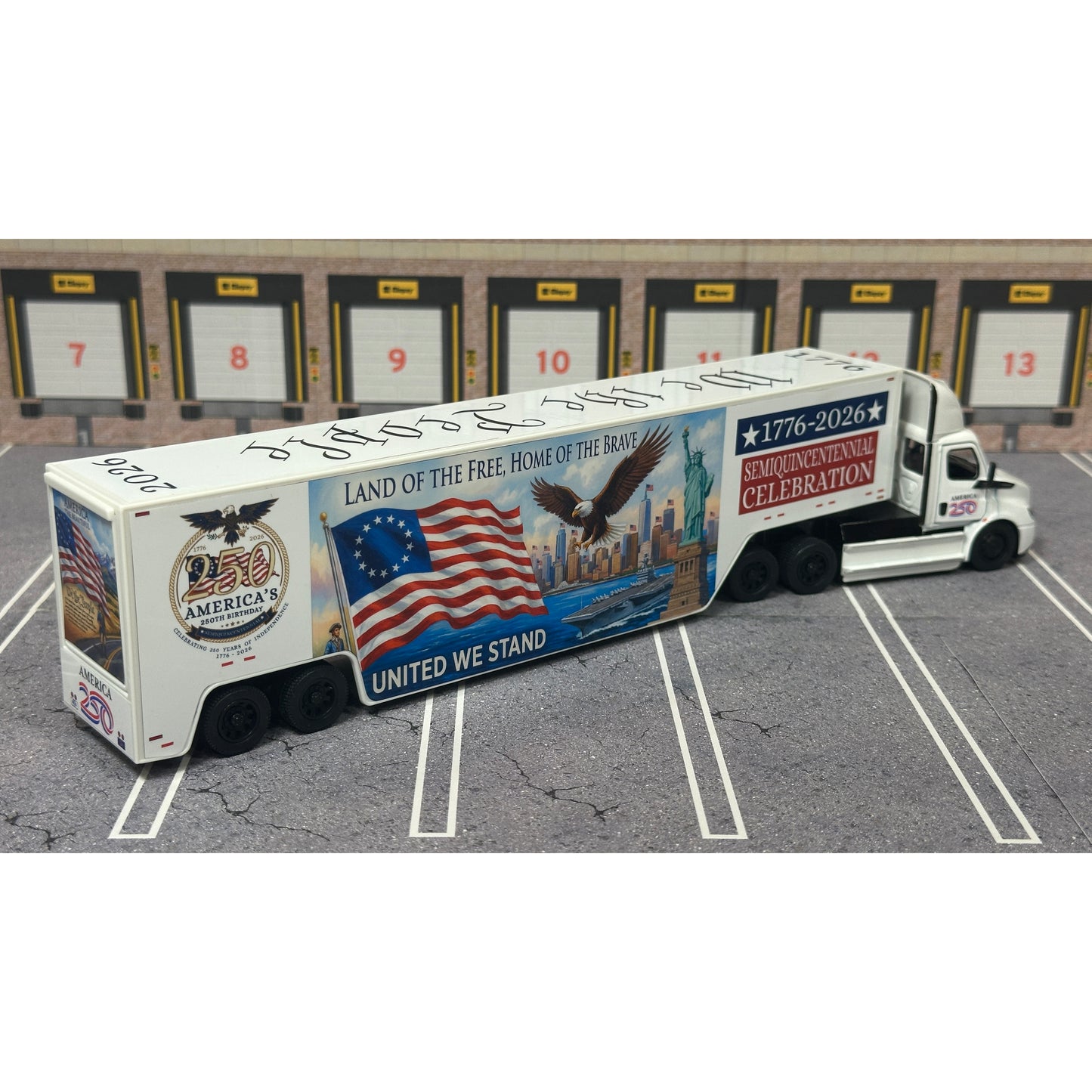 A diecast model of a Freightliner Cascadia semi-truck parked in a simulated parking lot. The trailer features a detailed historical design celebrating the United States' 250th anniversary with 'We the People' written on the top, alongside an American flag, eagle, and city skyline graphic with the text 'Land of the Free Home of the Brave' and 'United We Stand'.