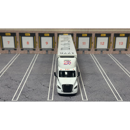A diecast model of a Freightliner Cascadia semi-truck parked in a simulated parking lot. The trailer features a detailed historical design celebrating the United States' 250th anniversary with 'We the People' written on the top, alongside an American flag, eagle, and city skyline graphic with the text 'Land of the Free Home of the Brave' and 'United We Stand'.