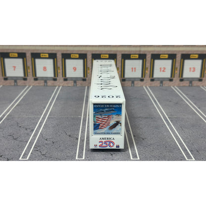 A diecast model of a Freightliner Cascadia semi-truck parked in a simulated parking lot. The trailer features a detailed historical design celebrating the United States' 250th anniversary with 'We the People' written on the top, alongside an American flag, eagle, and city skyline graphic with the text 'Land of the Free Home of the Brave' and 'United We Stand'.