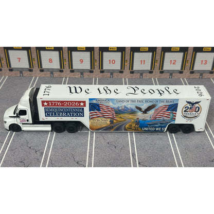 A diecast model of a Freightliner Cascadia semi-truck parked in a simulated parking lot. The trailer features a detailed historical design celebrating the United States' 250th anniversary with 'We the People' written on the top, alongside an American flag, eagle, and city skyline graphic with the text 'Land of the Free Home of the Brave' and 'United We Stand'.