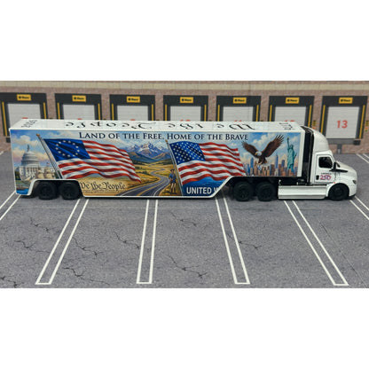 A diecast model of a Freightliner Cascadia semi-truck parked in a simulated parking lot. The trailer features a detailed historical design celebrating the United States' 250th anniversary with 'We the People' written on the top, alongside an American flag, eagle, and city skyline graphic with the text 'Land of the Free Home of the Brave' and 'United We Stand'.