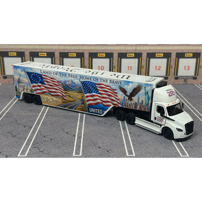 A diecast model of a Freightliner Cascadia semi-truck parked in a simulated parking lot. The trailer features a detailed historical design celebrating the United States' 250th anniversary with 'We the People' written on the top, alongside an American flag, eagle, and city skyline graphic with the text 'Land of the Free Home of the Brave' and 'United We Stand'.