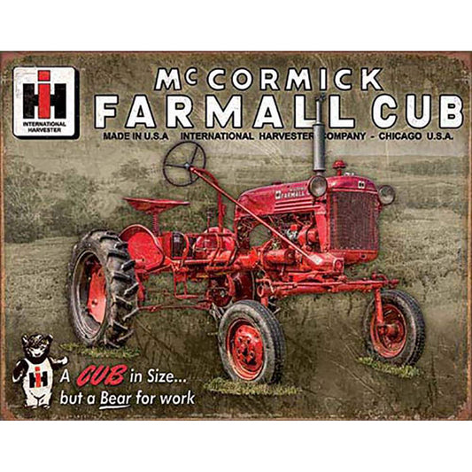 Vintage-style advertisement tin sign for McCormick Farmall Cub tractor with branding and text.