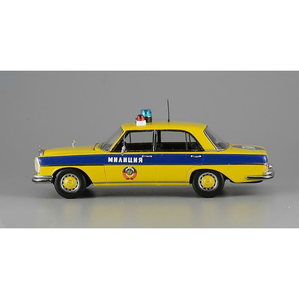 A 1975 Mercedes-Benz W108 'Moscow Police' model car in yellow, blue, and white colors with black wheels and interior.