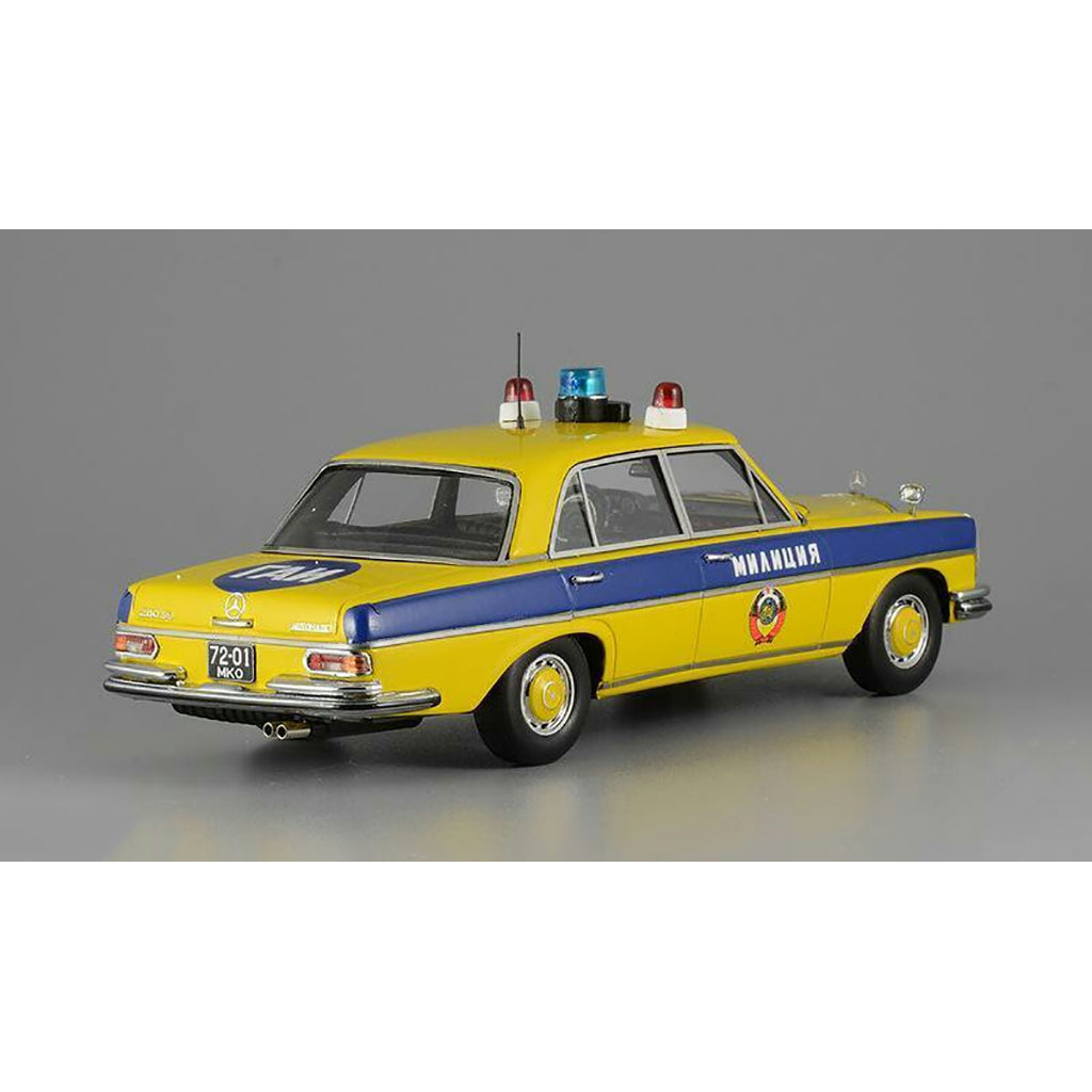 A 1975 Mercedes-Benz W108 'Moscow Police' model car in yellow, blue, and white colors with black wheels and interior.