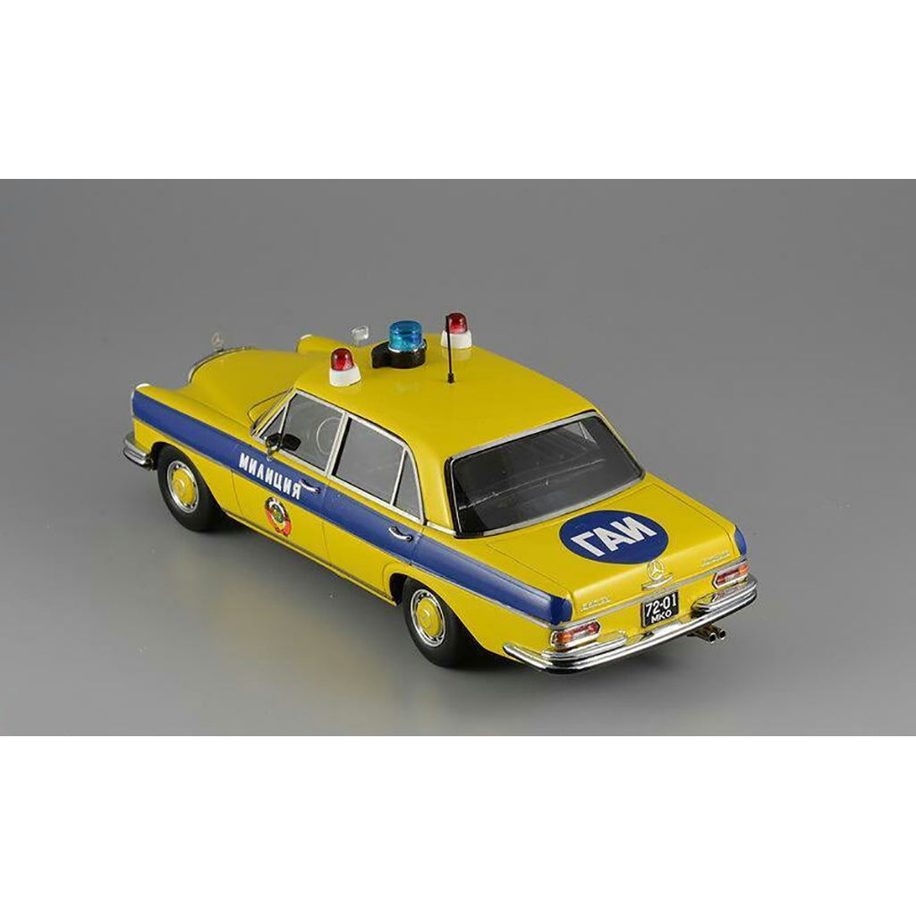 A 1975 Mercedes-Benz W108 'Moscow Police' model car in yellow, blue, and white colors with black wheels and interior.