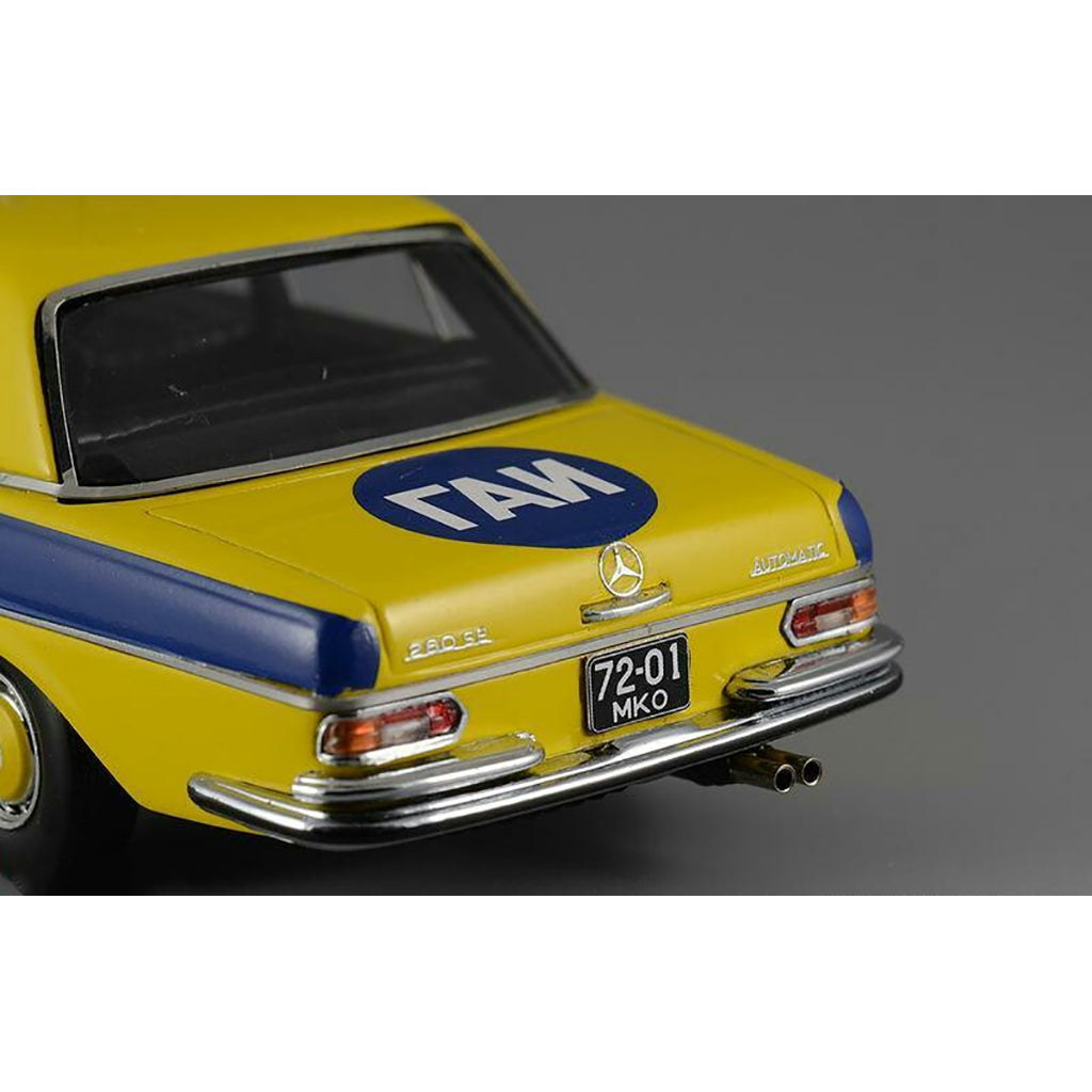 A 1975 Mercedes-Benz W108 'Moscow Police' model car in yellow, blue, and white colors with black wheels and interior.