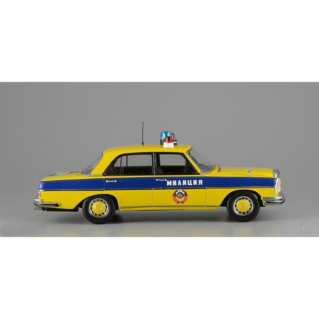 A 1975 Mercedes-Benz W108 'Moscow Police' model car in yellow, blue, and white colors with black wheels and interior.