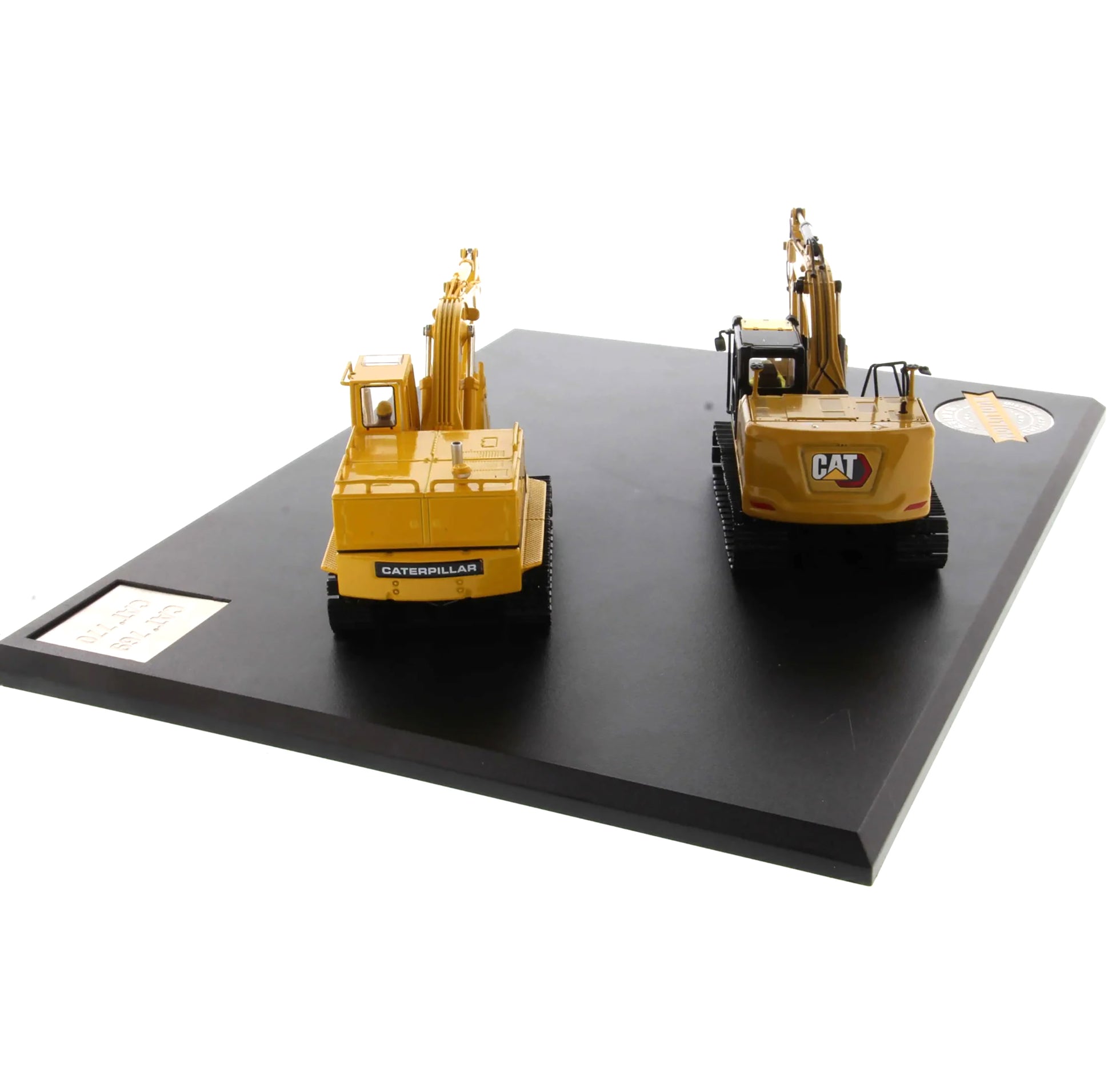 Two model Caterpillar excavators on a black platform with a white background