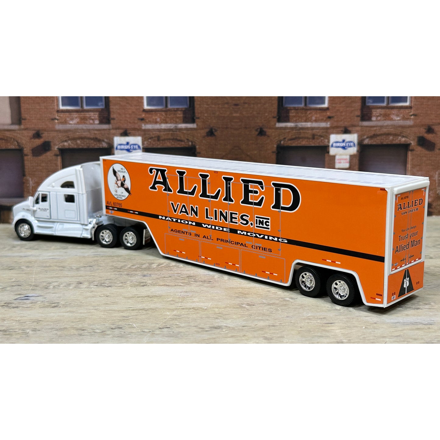 Model of a Allied Van Lines truck in front of a brick building.