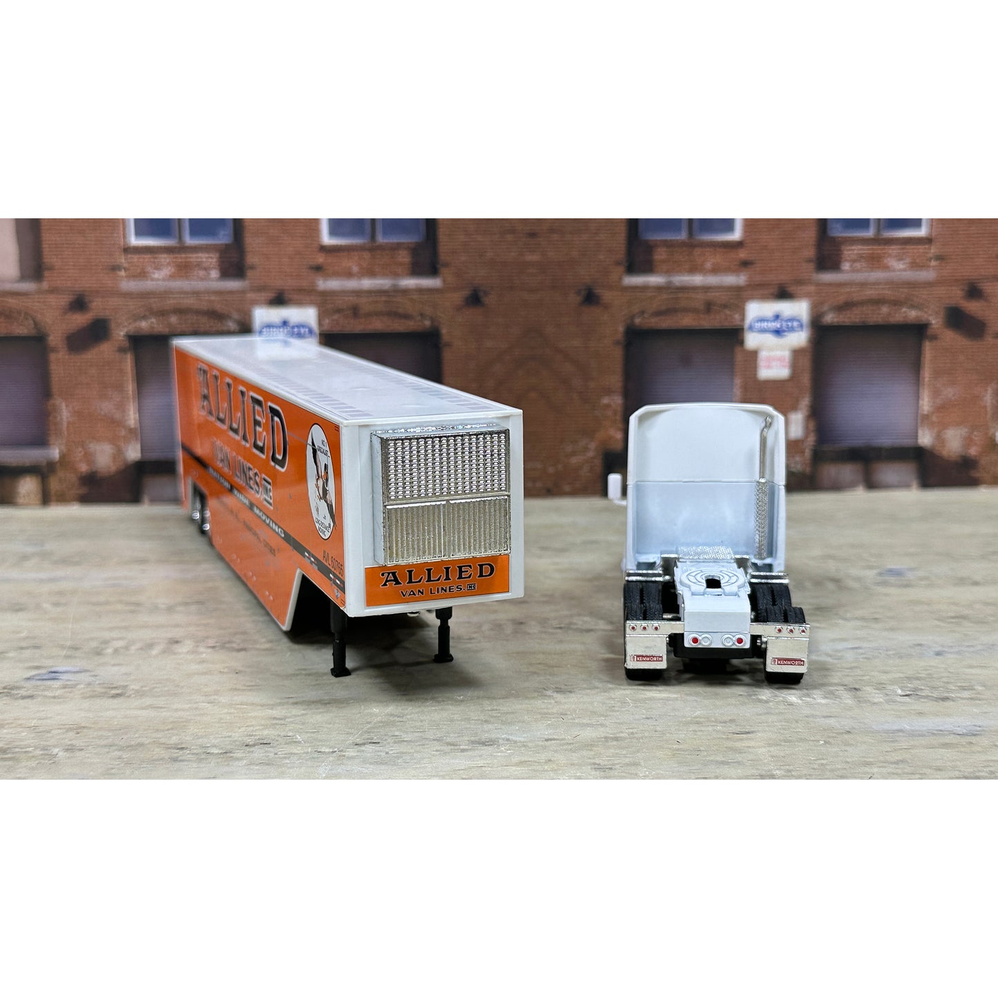 Model of a truck with 'Allied' branding in front of a brick building.