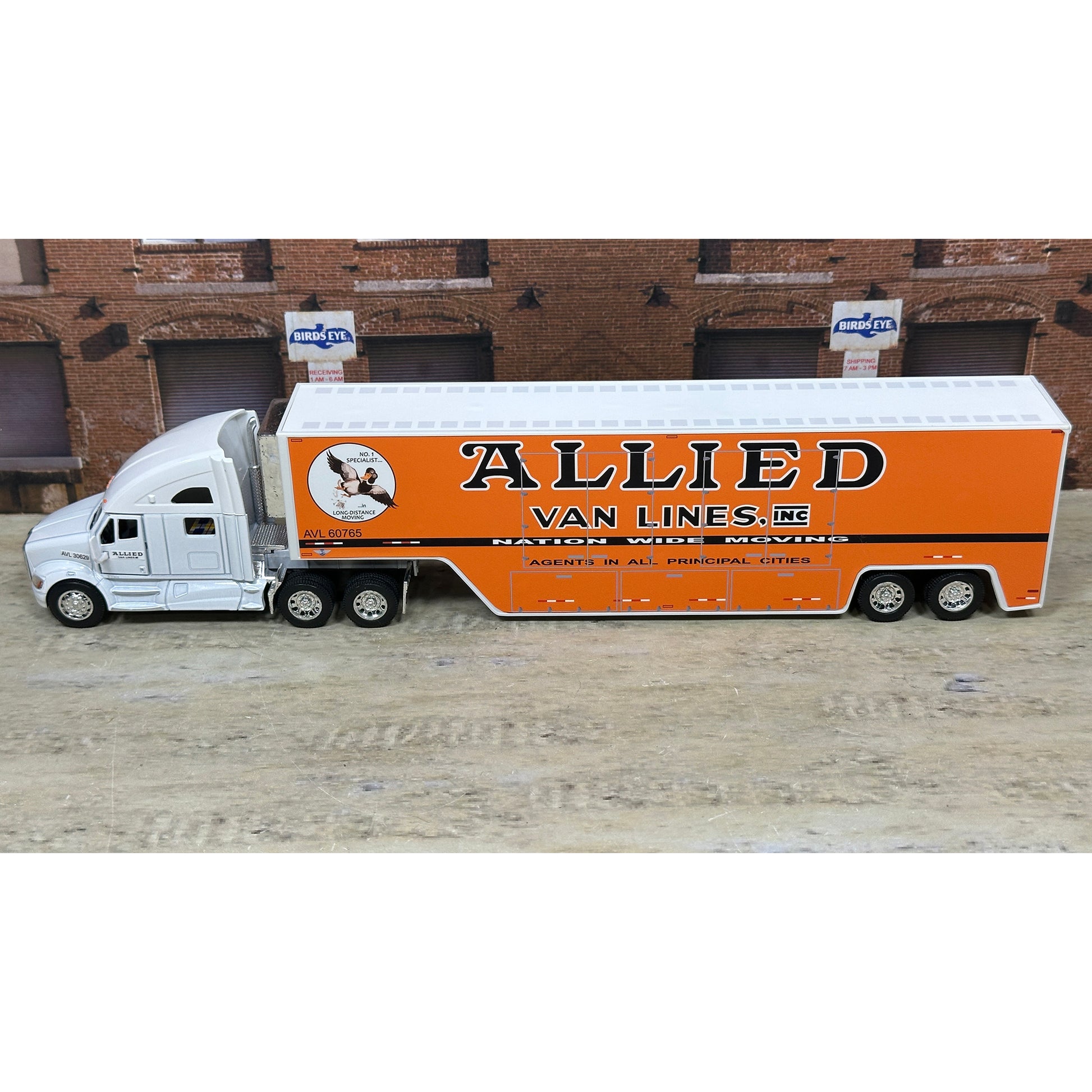 Model truck with 'Allied Van Lines' branding on a wooden surface.