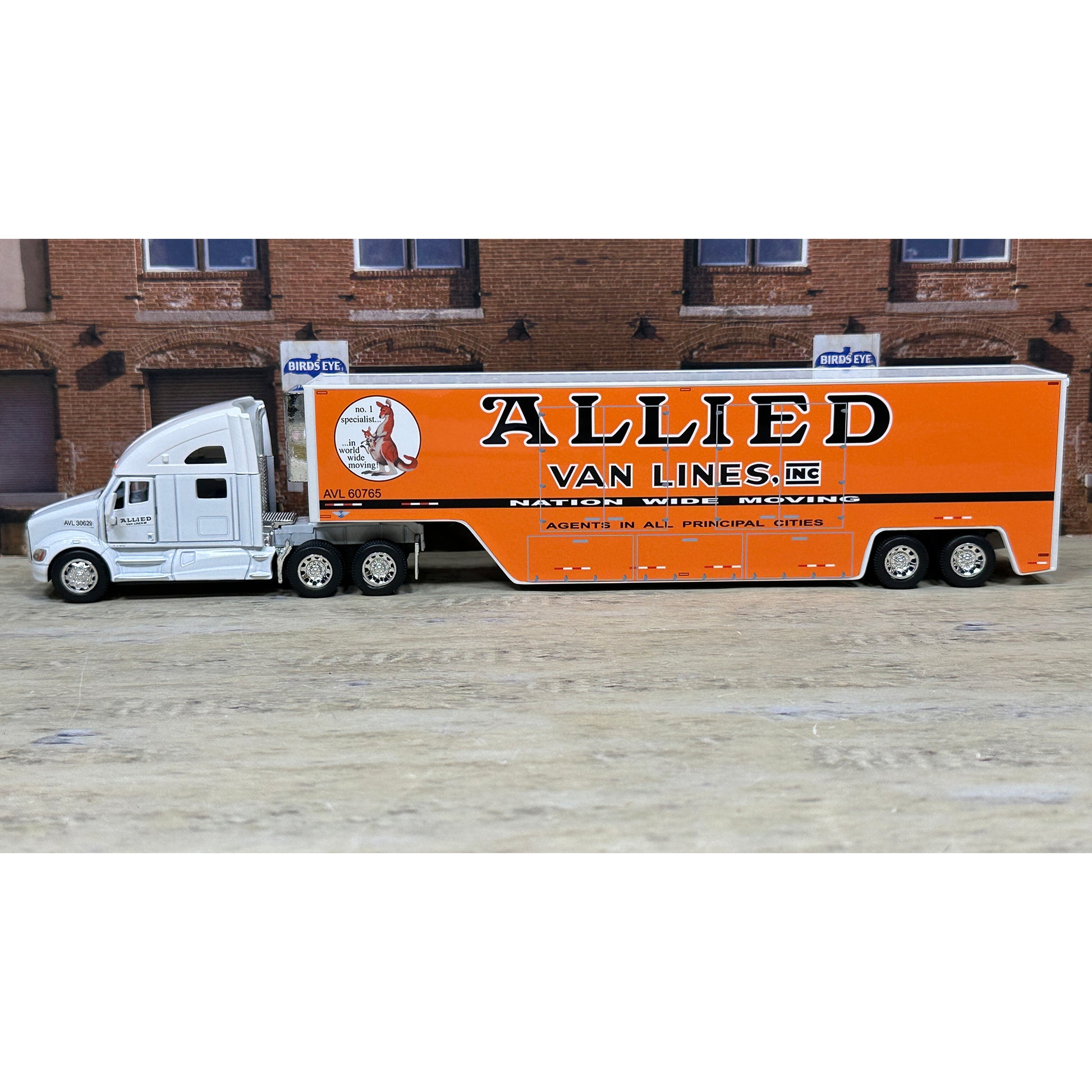 Model truck with 'Allied Van Lines' branding in front of a brick building.