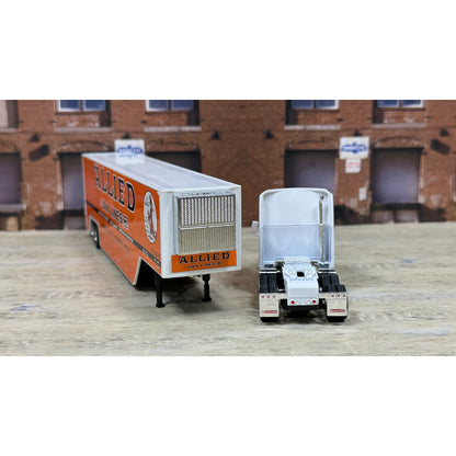Model of a truck with 'Allied' branding in front of a brick building.