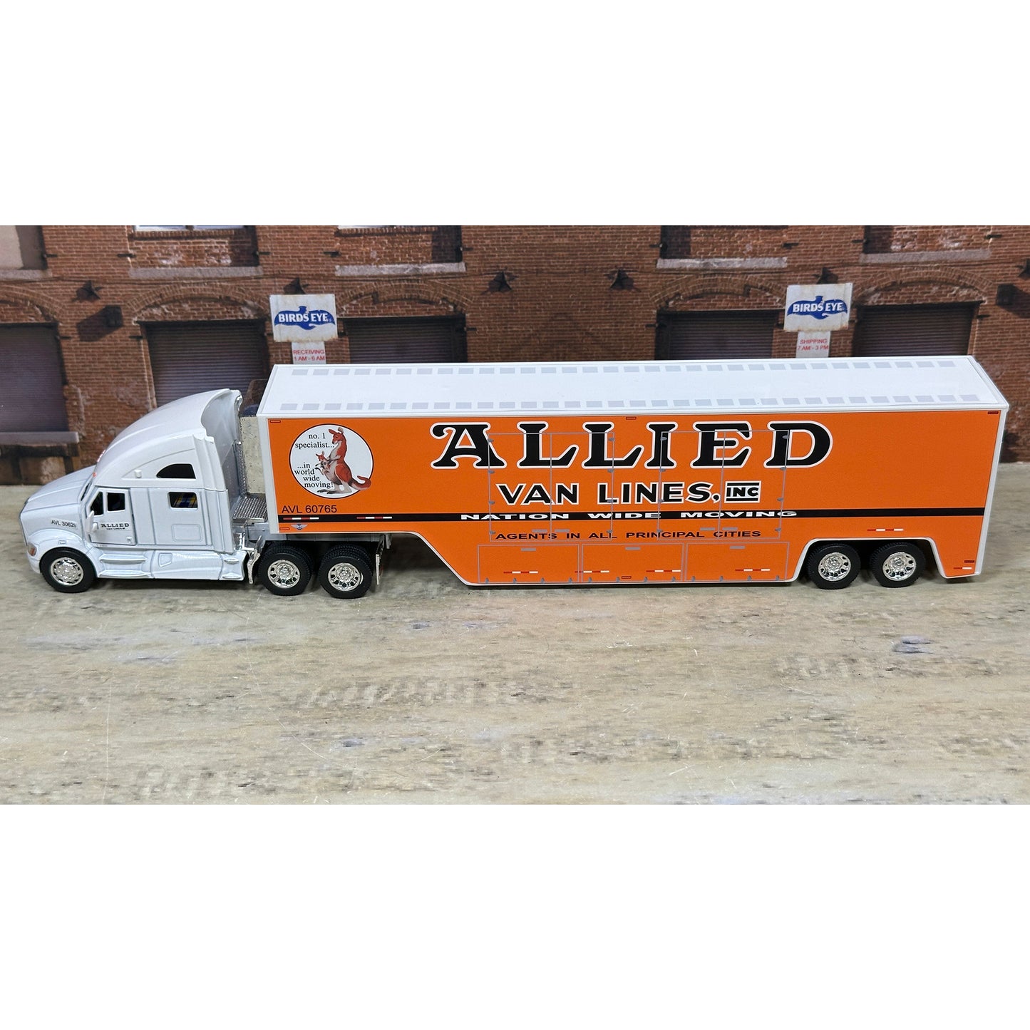 Model of a truck with 'Allied Van Lines, Inc.' branding on a wooden surface.