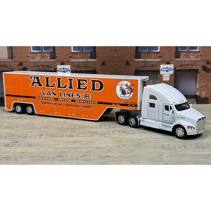 Model of a semi-truck with an orange trailer labeled 'Allied Van Lines' in front of a brick building.