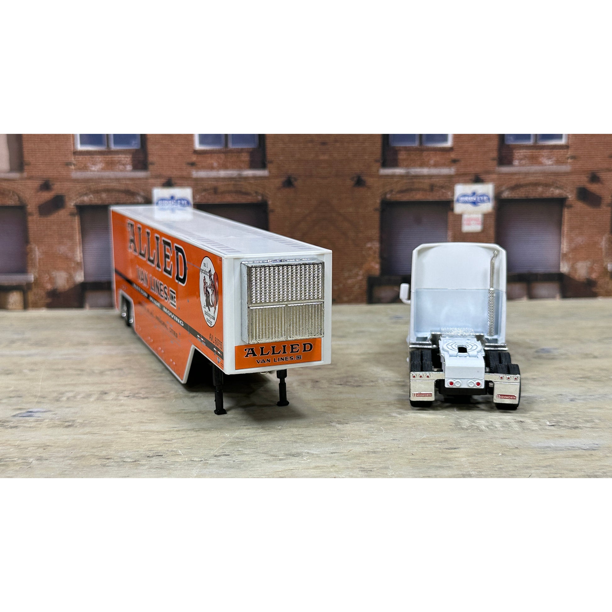 Model of a truck with 'Allied' branding in front of a brick building.