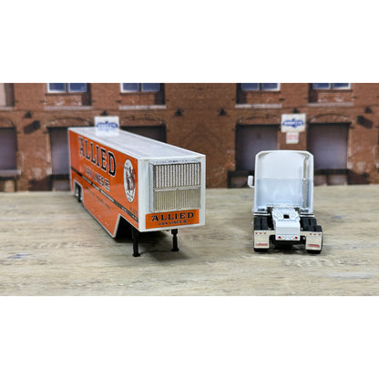 Model of a truck with 'Allied' branding in front of a brick building.