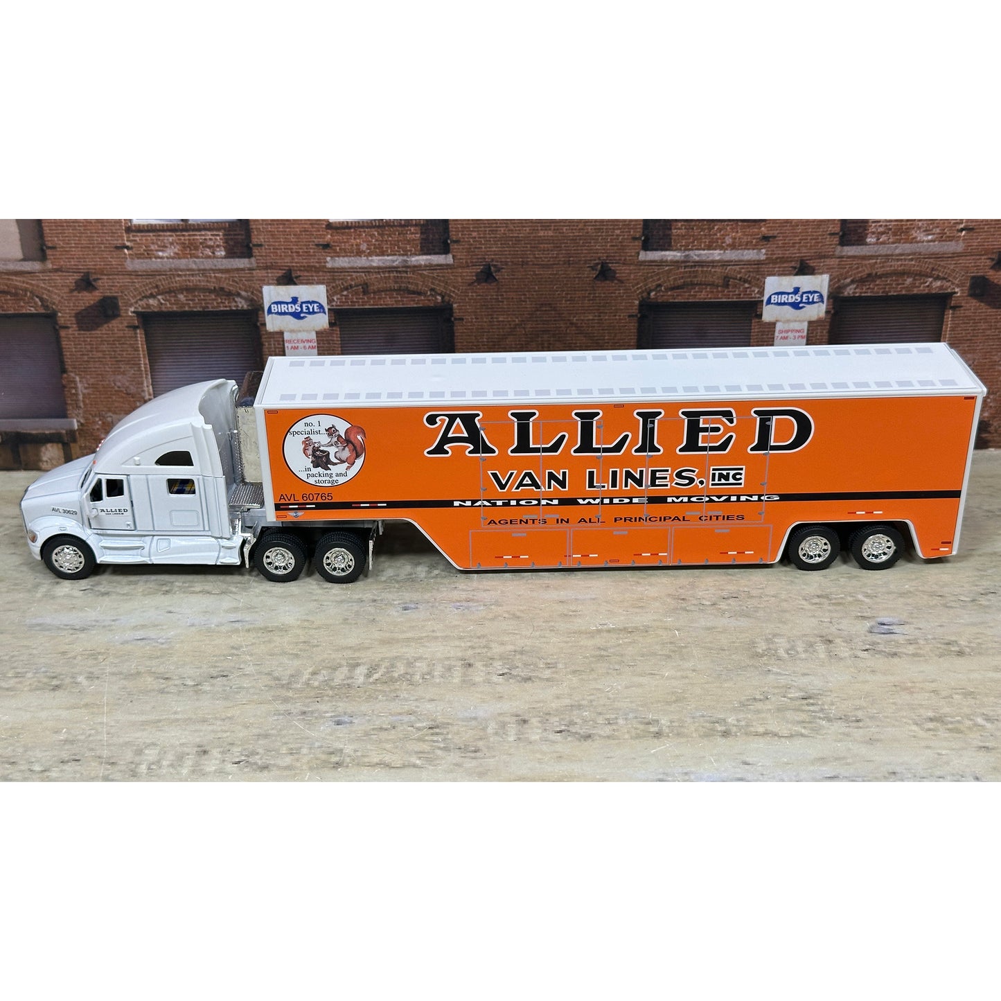 Model truck with 'Allied Van Lines' branding on a wooden surface.