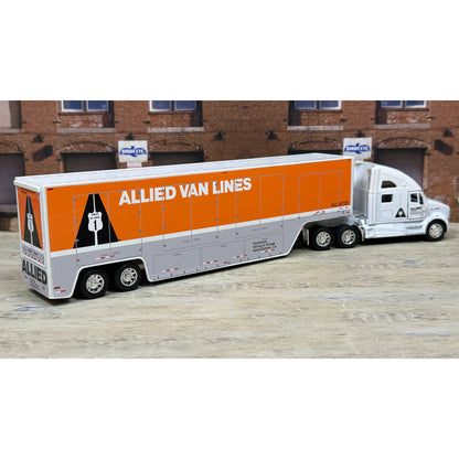 Model of a semi-truck with 'Allied Van Lines' branding in front of a brick building.