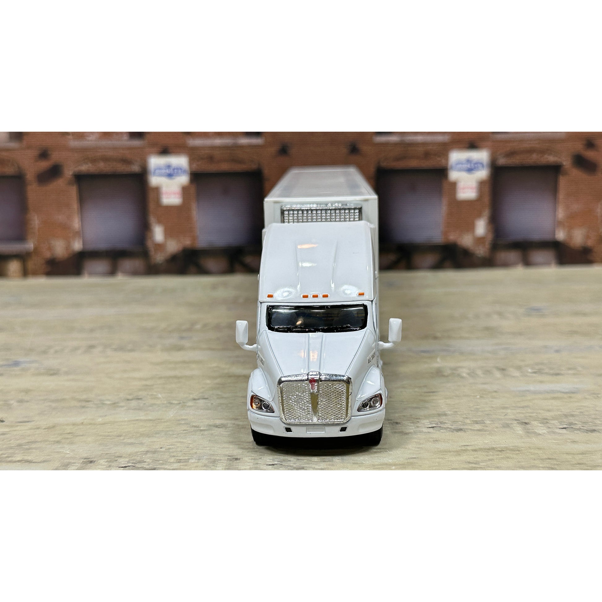 Model of a white truck with a trailer on a wooden surface