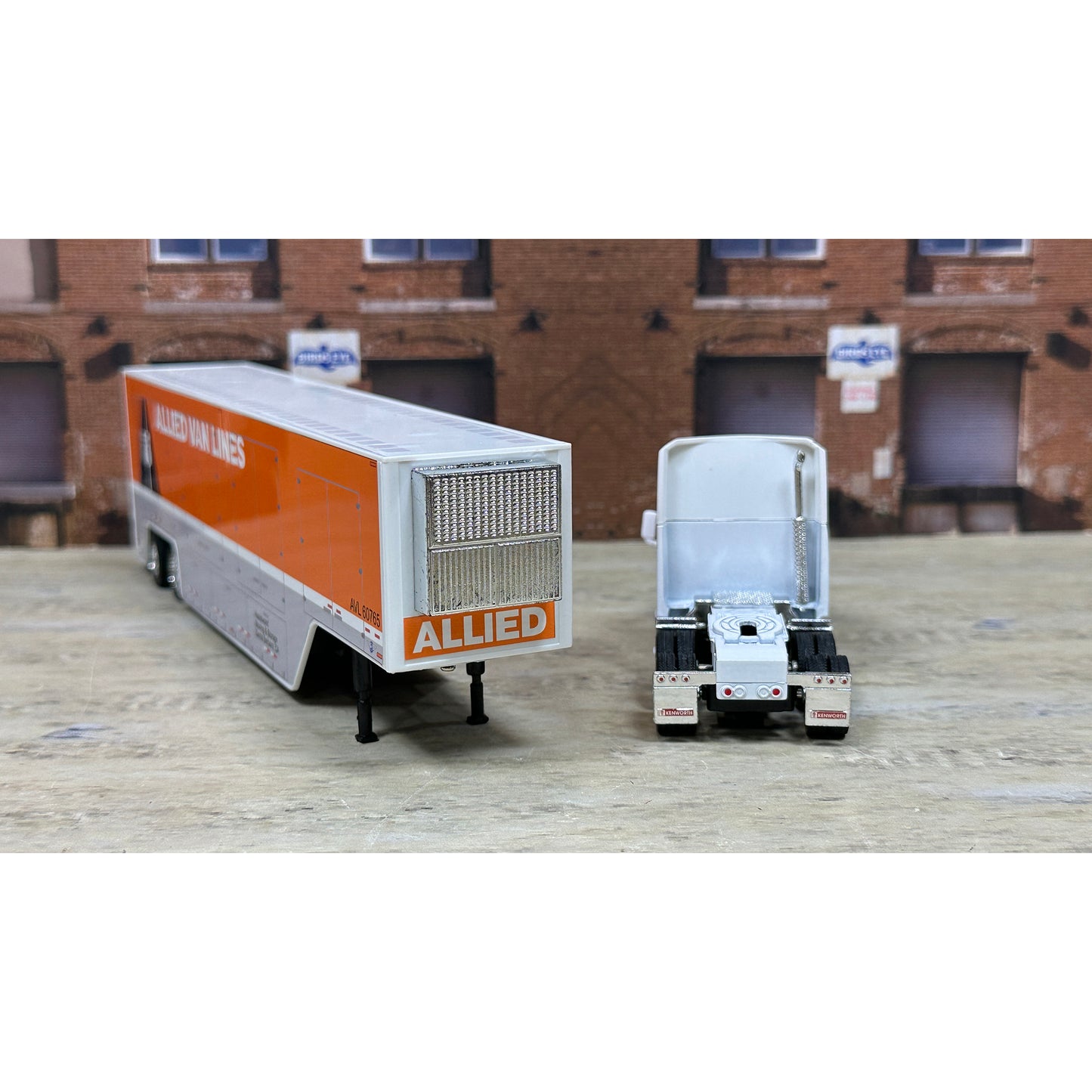 Model of a truck with 'Allied' branding in front of a brick building.