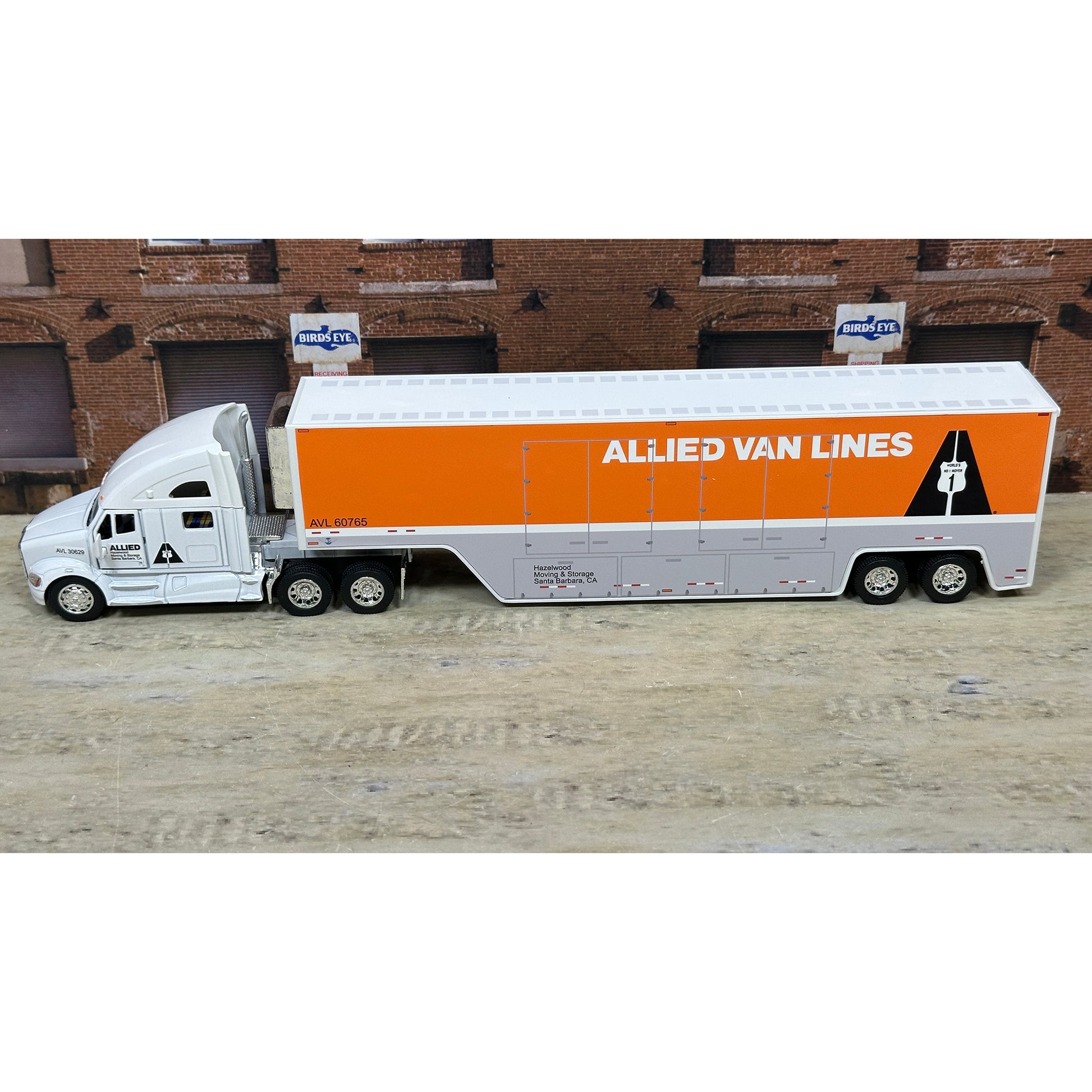 Model of a truck with 'Allied Van Lines' branding on a wooden surface.